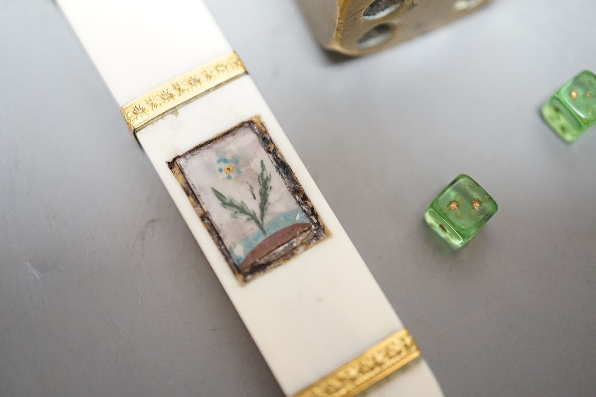 A late 18th century ivory and gold mounted needle case, two brass dice and three mini dice